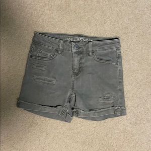 Faded green ripped denim shorts